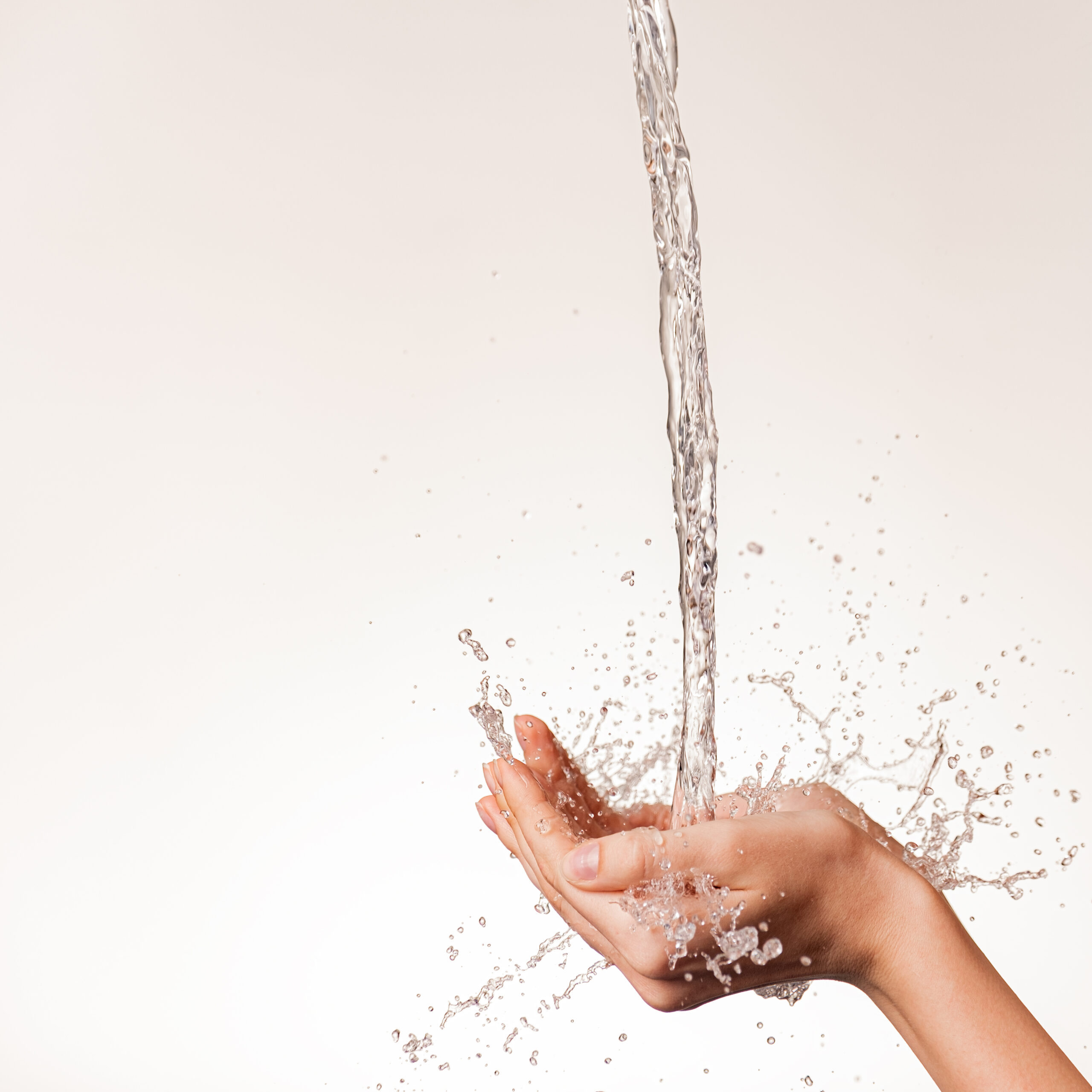 Photo of women's hands on which a stream of clean water pours. H